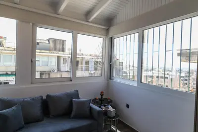 a living room with a couch and large windows at Triple A - Acropolis View in Psiri Athens - FREE Parking! in Athens
