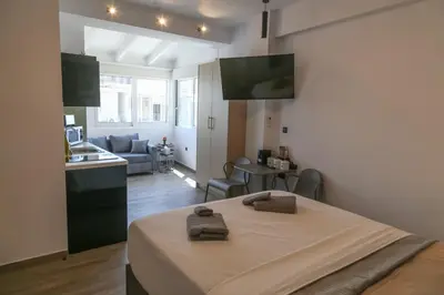 a kitchen and a living room with a bed in a room at Triple A - Acropolis View in Psiri Athens - FREE Parking! in Athens