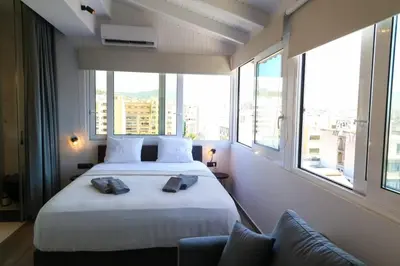 a bedroom with a large bed and large windows at Triple A - Acropolis View in Psiri Athens - FREE Parking! in Athens
