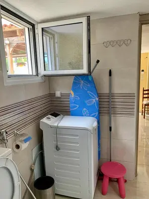 a small bathroom with a toilet and a surfboard at Sofia's Seaview Villa Near Airport And Beach in Artemida