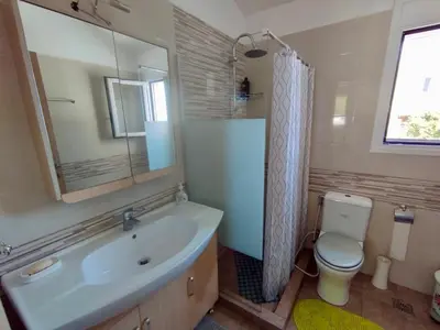 a bathroom with a sink and a toilet and a mirror at Sofia's Seaview Villa Near Airport And Beach in Artemida