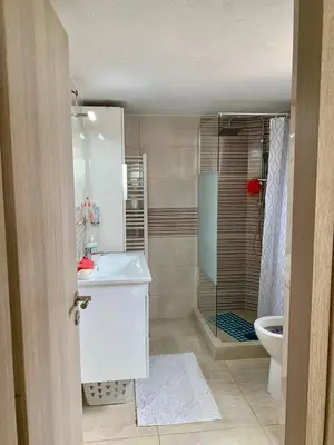 a bathroom with a shower and a sink and a toilet at Sofia's Seaview Villa Near Airport And Beach in Artemida
