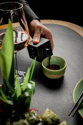 a person pouring wine into a bowl on a table at Academias Hotel, Autograph Collection in Athens