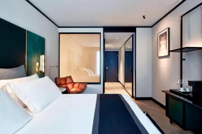 a bedroom with a large bed and a living room at Academias Hotel, Autograph Collection in Athens