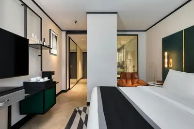 a bedroom with a large bed and a flat screen tv at Academias Hotel, Autograph Collection in Athens