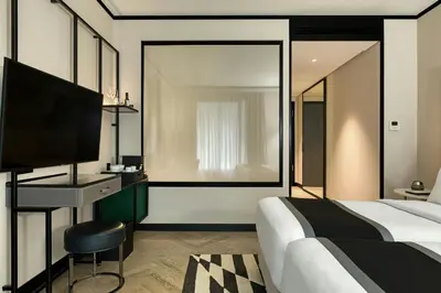 a bedroom with a bed and a desk and a television at Academias Hotel, Autograph Collection in Athens