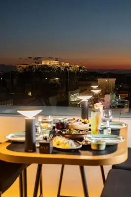a table with plates of food on a balcony at Academias Hotel, Autograph Collection in Athens