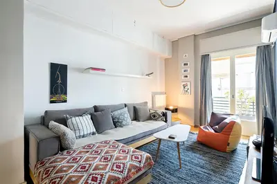 a living room with a couch and a chair at Olympic Mets Apartment in Athens