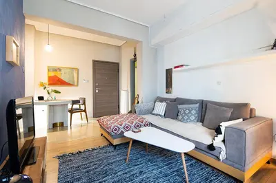 a living room with a couch and a table at Olympic Mets Apartment in Athens