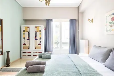 a bedroom with a large bed and a window at Olympic Mets Apartment in Athens