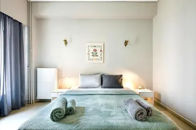 a bedroom with a bed with towels on it at Olympic Mets Apartment in Athens
