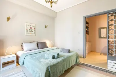 a bedroom with a bed with a green blanket at Olympic Mets Apartment in Athens
