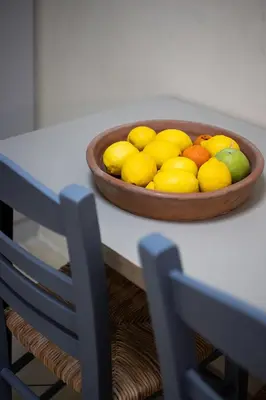 a bowl of fruit on a table with a bowl of lemons at Olympic Mets Apartment in Athens