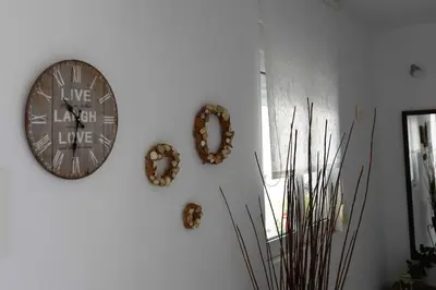 a clock hanging on a wall with wreaths on it at INSPIRATION Guestroom with Amazing Roof Garden in Athens