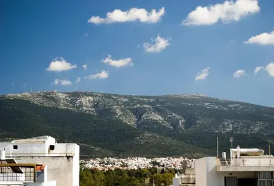 a view of a city with a mountain in the background at INSPIRATION Guestroom with Amazing Roof Garden in Athens