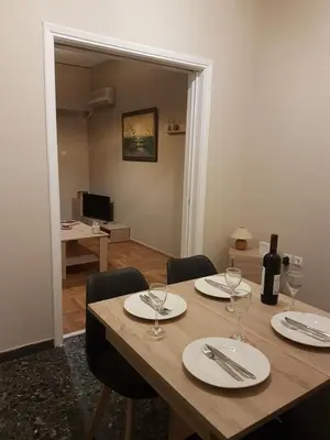 a wooden table with wine glasses on top of it at Katehaki Metro Flat in Athens