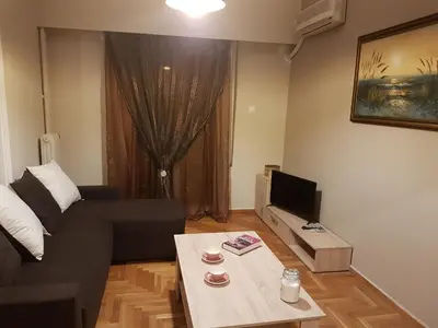 a living room with a couch and a table at Katehaki Metro Flat in Athens