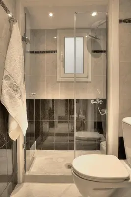 a bathroom with a toilet and a glass shower at Downtown Glyfada smart apartment in Athens