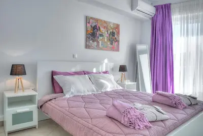 a bedroom with a purple bed with purple curtains at Downtown Glyfada smart apartment in Athens
