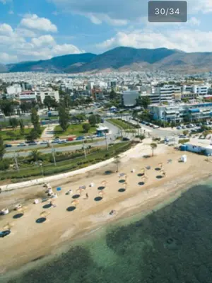 an aerial view of a beach with cars and a city at Downtown Glyfada smart apartment in Athens
