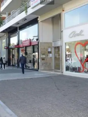 a man walking down a street in front of a store at Downtown Glyfada smart apartment in Athens