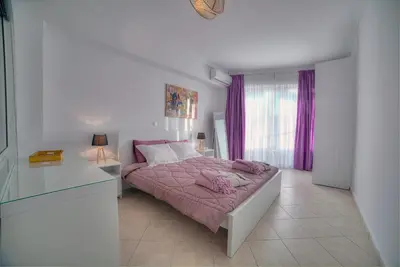 a bedroom with a bed with pink sheets and a window at Downtown Glyfada smart apartment in Athens