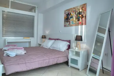 a bedroom with a pink bed and a mirror at Downtown Glyfada smart apartment in Athens