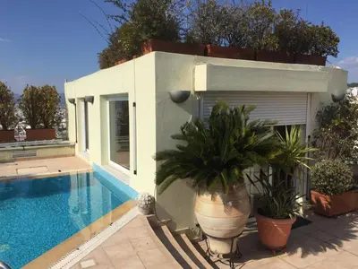 a villa with a swimming pool next to a house at Luxury Penthouse with Private Roof Swimming Pool in Athens