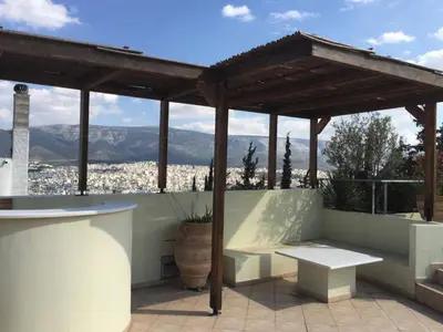 a pergola with a table and bench on a patio at Luxury Penthouse with Private Roof Swimming Pool in Athens