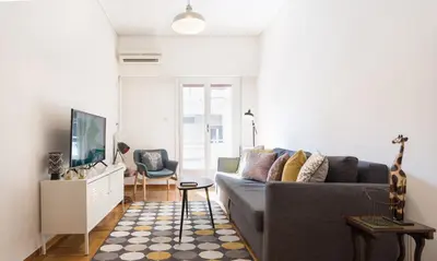 a living room with a couch and a tv at 1 KM from The Acropolis 1 Bedroom Apt in Athens