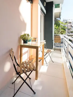 a table and chairs on the balcony of a house at 1 KM from The Acropolis 1 Bedroom Apt in Athens