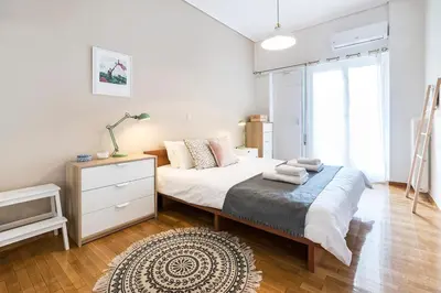 a white bedroom with a bed and a television at 1 KM from The Acropolis 1 Bedroom Apt in Athens