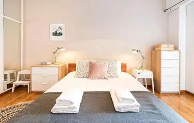 a bedroom with a large white bed and two night stands at 1 KM from The Acropolis 1 Bedroom Apt in Athens