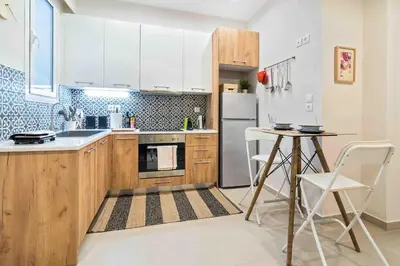 a kitchen with white appliances and a table and chairs at Athens' Top Location Romantic & Well Decor Shining Star in Athens