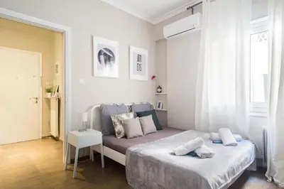 a bedroom with a bed in a white room at Your stay next to Acropolis! in Athens