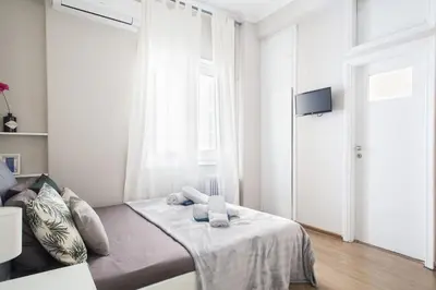 a white bedroom with a bed with towels on it at Your stay next to Acropolis! in Athens