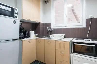 a kitchen with wooden cabinets and a white refrigerator at Your stay next to Acropolis! in Athens