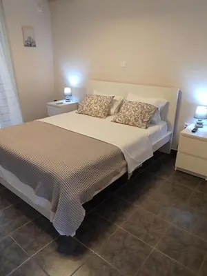 a bedroom with a large bed with two night stands at Double M near Athens Airport in Markopoulo