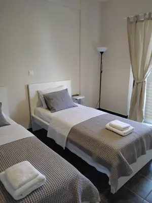 a bedroom with two beds with towels on them at Double M near Athens Airport in Markopoulo