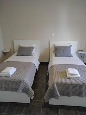 two beds sitting next to each other in a room at Double M near Athens Airport in Markopoulo