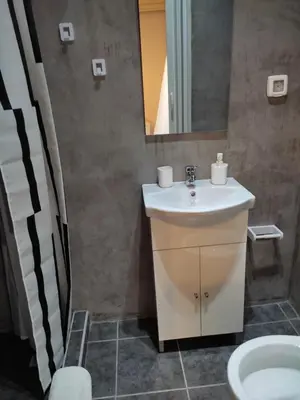 a bathroom with a sink and a mirror and a toilet at Double M near Athens Airport in Markopoulo