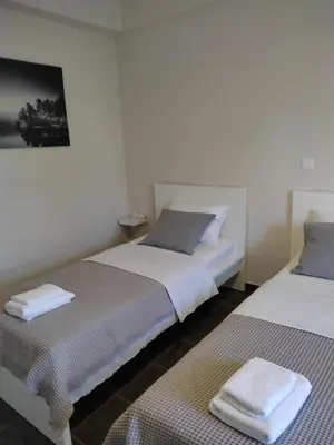 two beds sitting next to each other in a room at Double M near Athens Airport in Markopoulo
