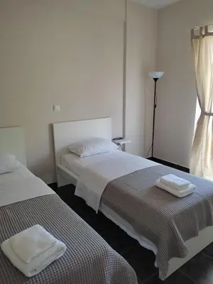 two beds sitting next to each other in a bedroom at Double M near Athens Airport in Markopoulo