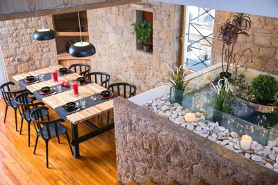 a restaurant with tables and chairs and a stone wall at One-of-a-kind Athens Riviera Apartment in Athens