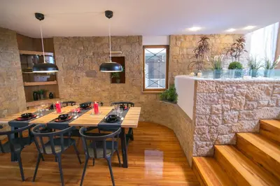 a restaurant with wooden tables and chairs and a stone wall at One-of-a-kind Athens Riviera Apartment in Athens