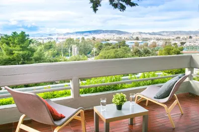 a balcony with chairs and a table and a view at One-of-a-kind Athens Riviera Apartment in Athens