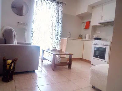 a living room with a couch and a table in front of a window at Φωτεινό διαμέρισμα Πειραιας in Piraeus