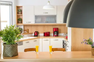a kitchen with a table with two glasses of orange juice at Athens luxurious apartment - sea view! in Athens