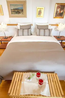 a large bed with two red glasses on a table at Athens luxurious apartment - sea view! in Athens