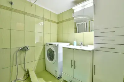 a bathroom with a washing machine and a sink at Manolitos Apartments 5 in Athens